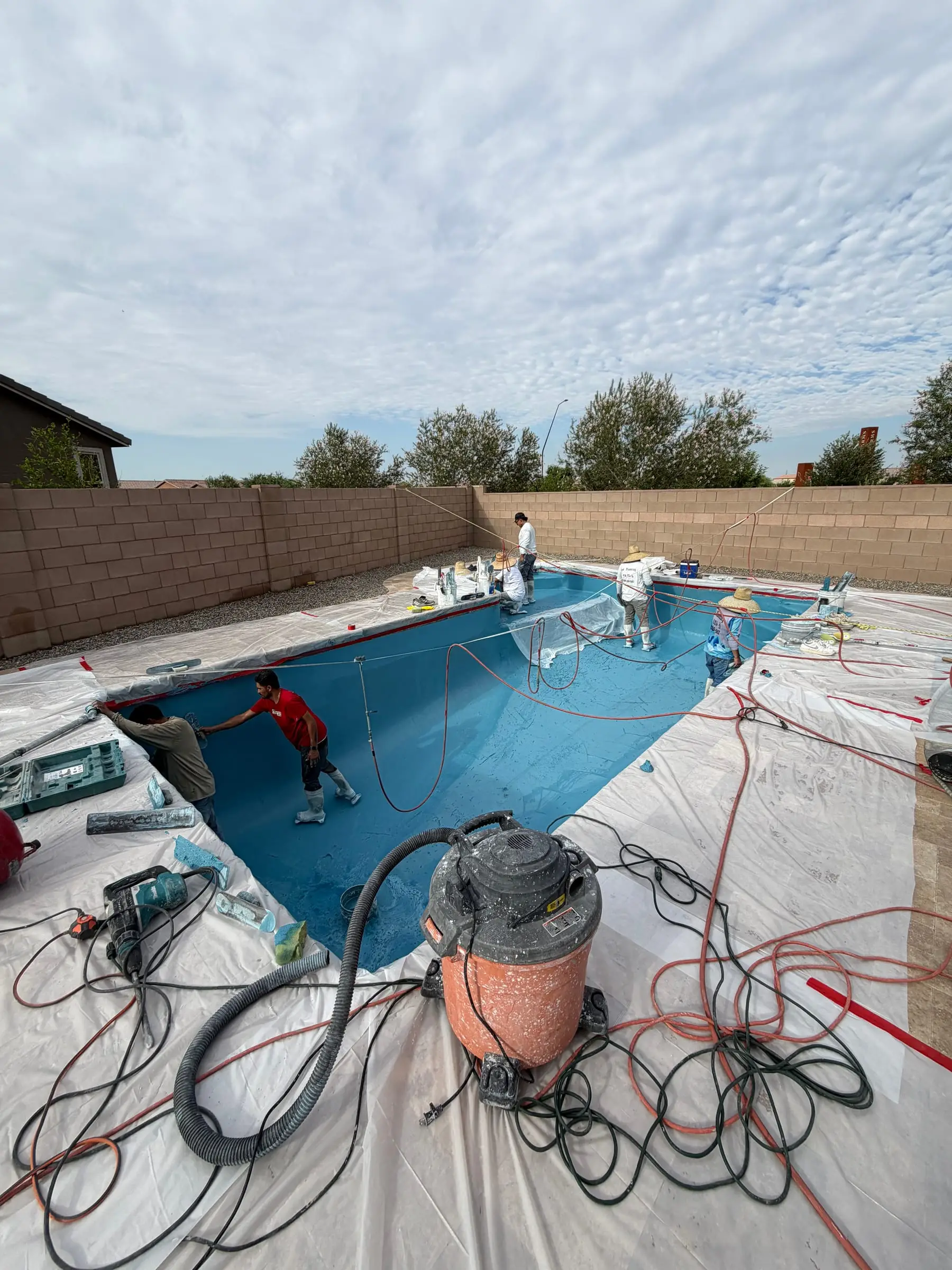 Our crew applying a light blue interior finish to a rectangular pool.