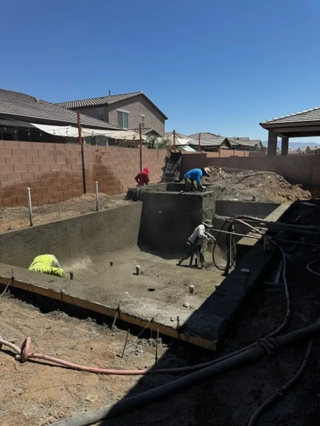 Crew applying shotcrete to form the pool shell, bench and raised walls.