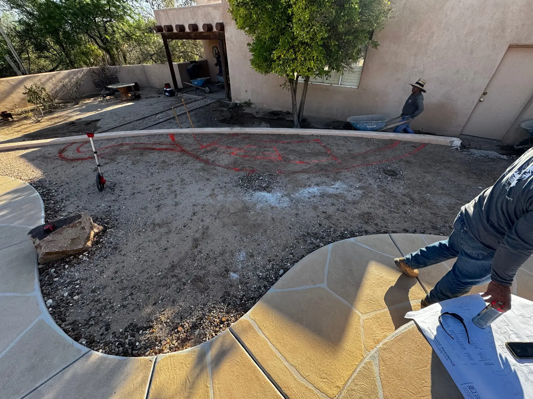Hardscape layout painted in a backyard while our crew checks the plans.