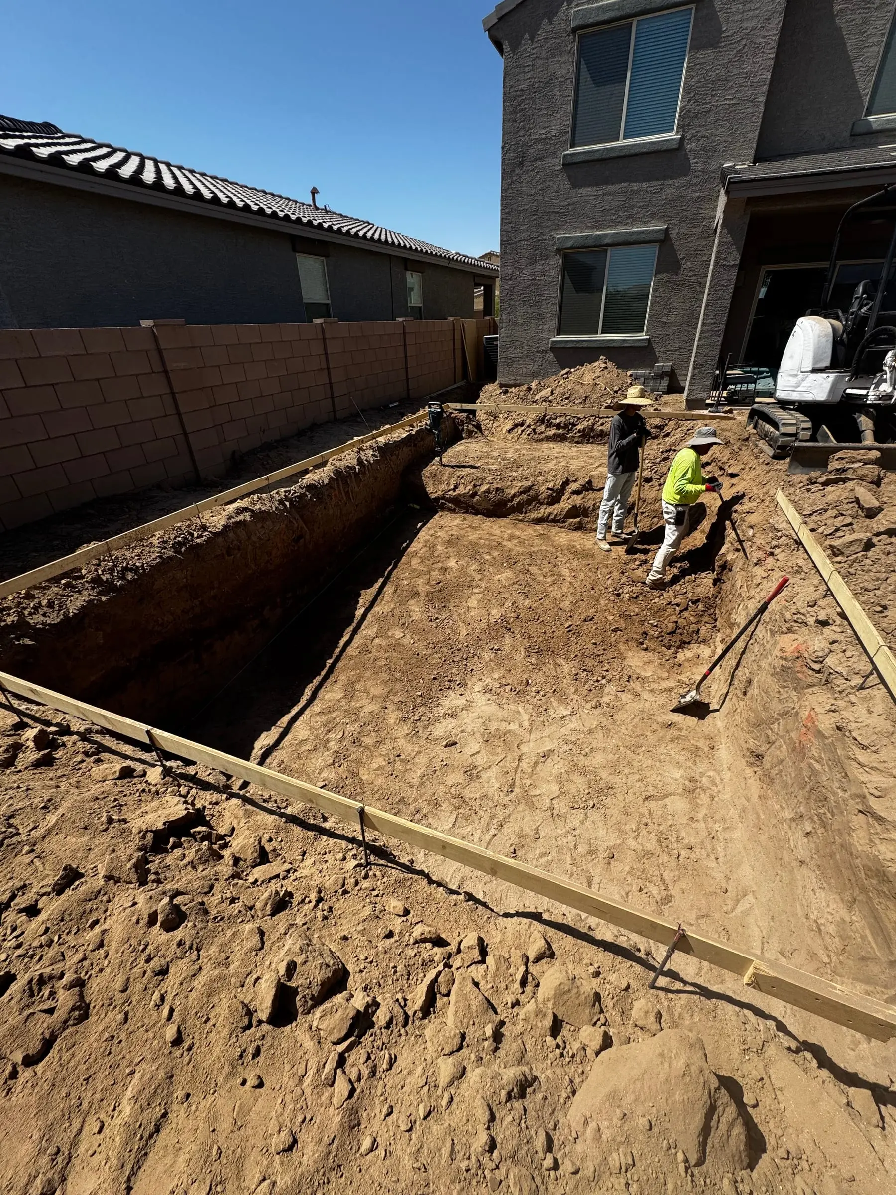 Our crew digging and forming a rectangular pool beside a two-story home in Marana.