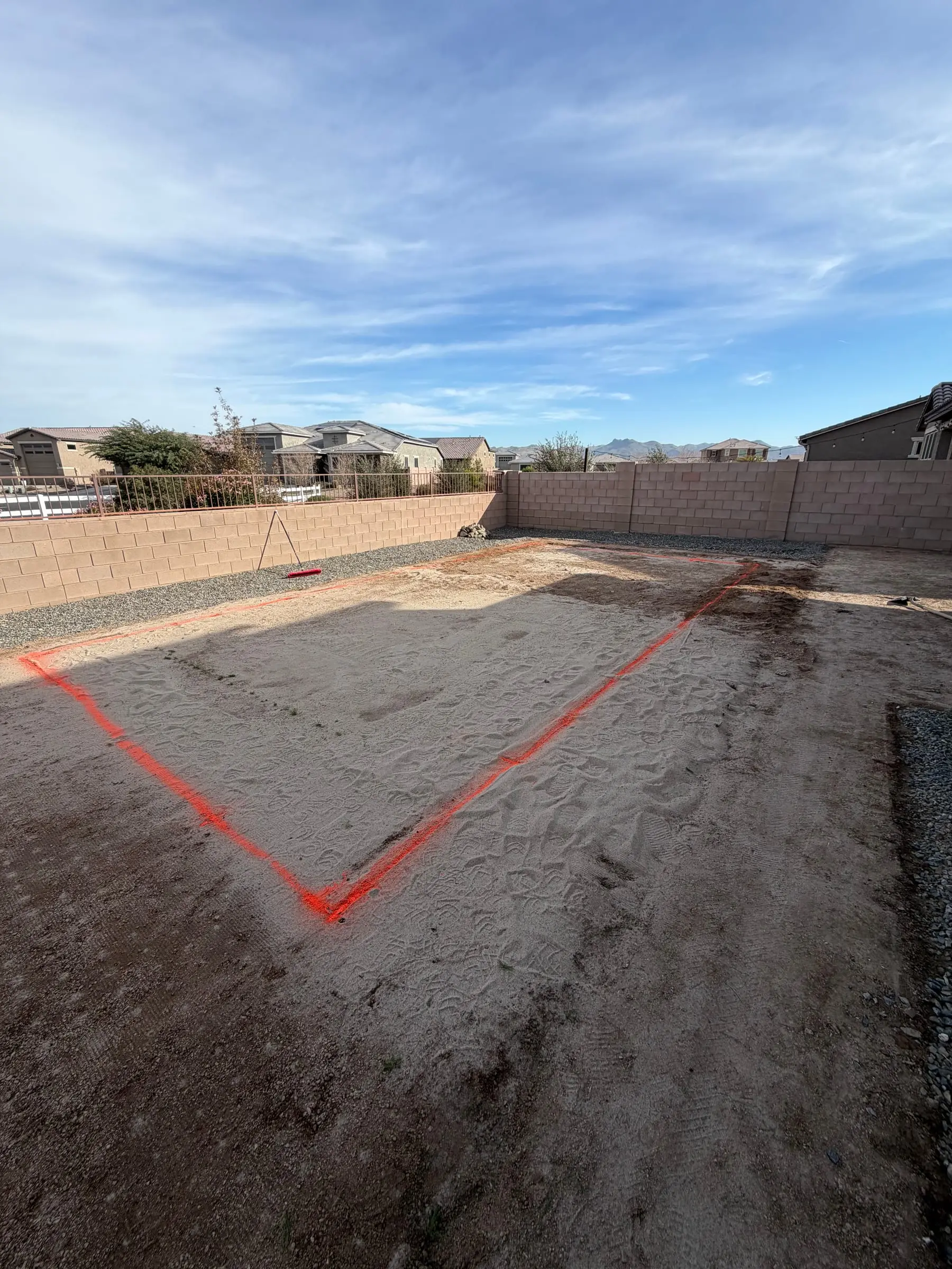 Pool outline painted in orange on a cleared backyard in Gladden Farms.
