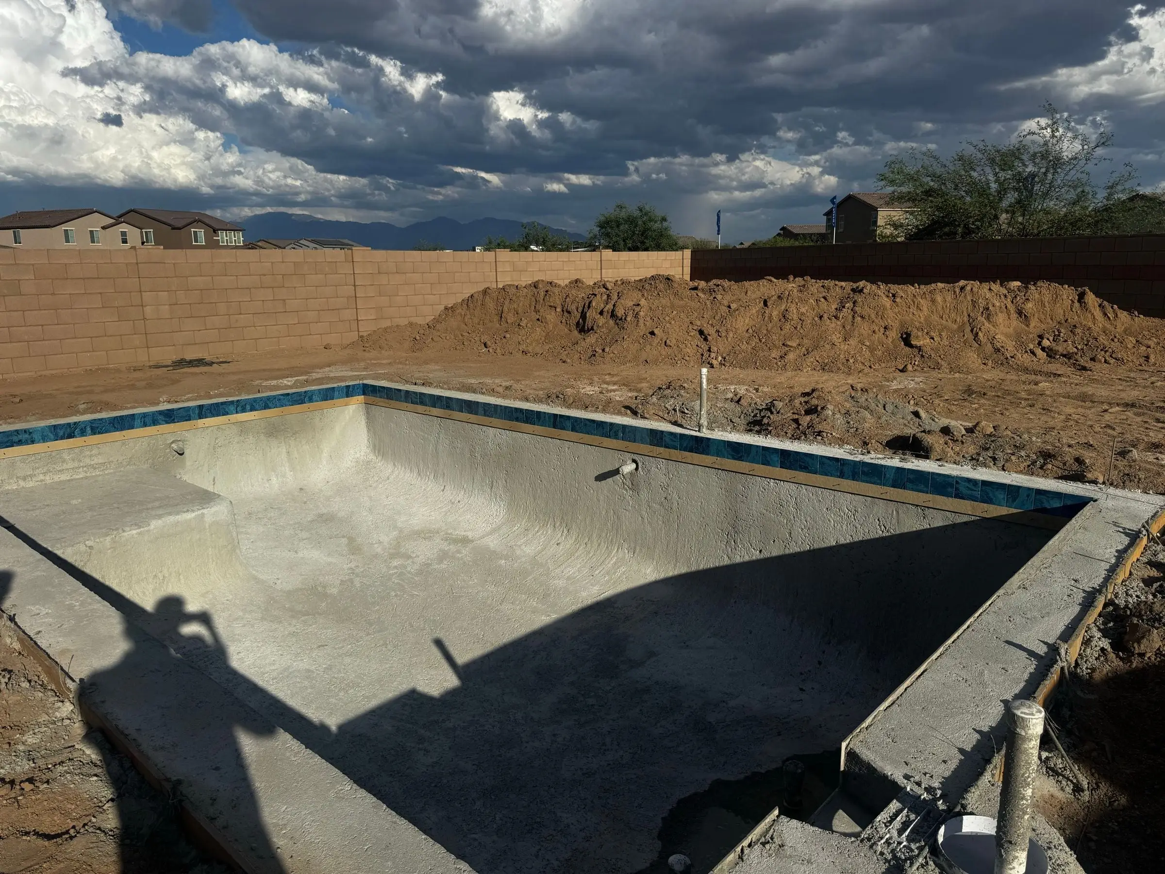Rectangular pool shell with blue waterline tile installed, ready for plaster.