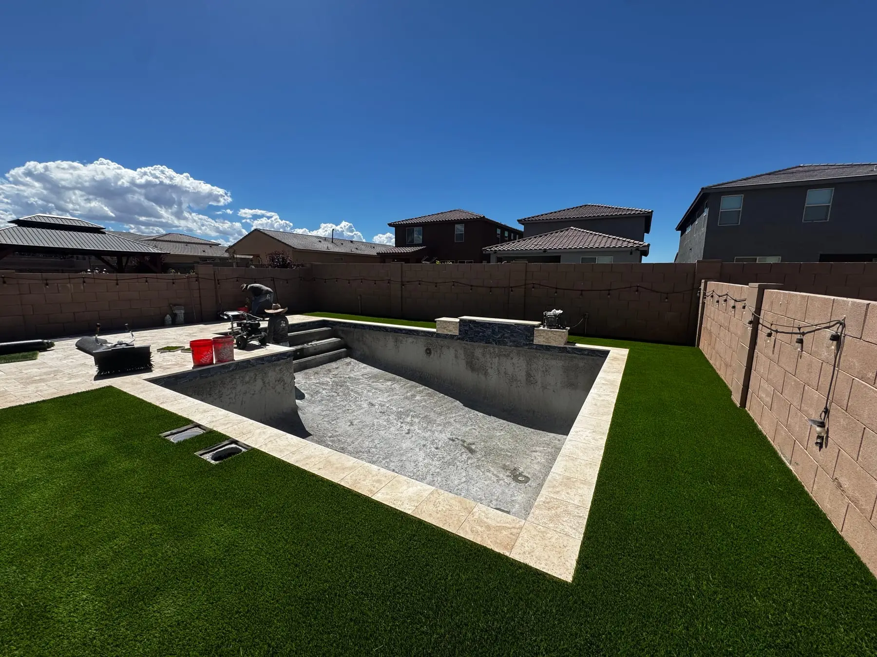 Pool shell with travertine coping set and new turf laid around it, southeast Tucson, AZ.