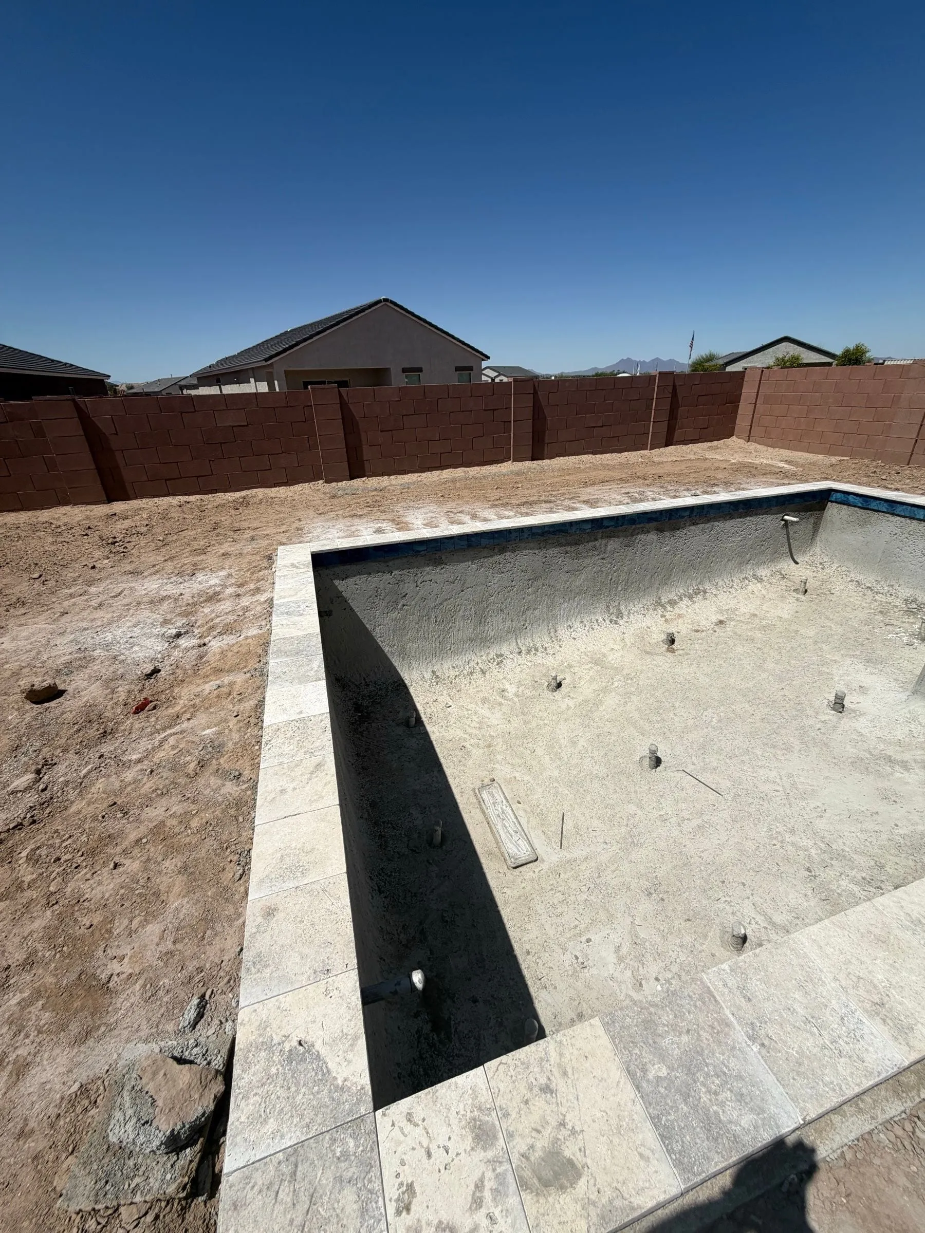 Rectangular pool shell with travertine coping set and ready for the interior finish.