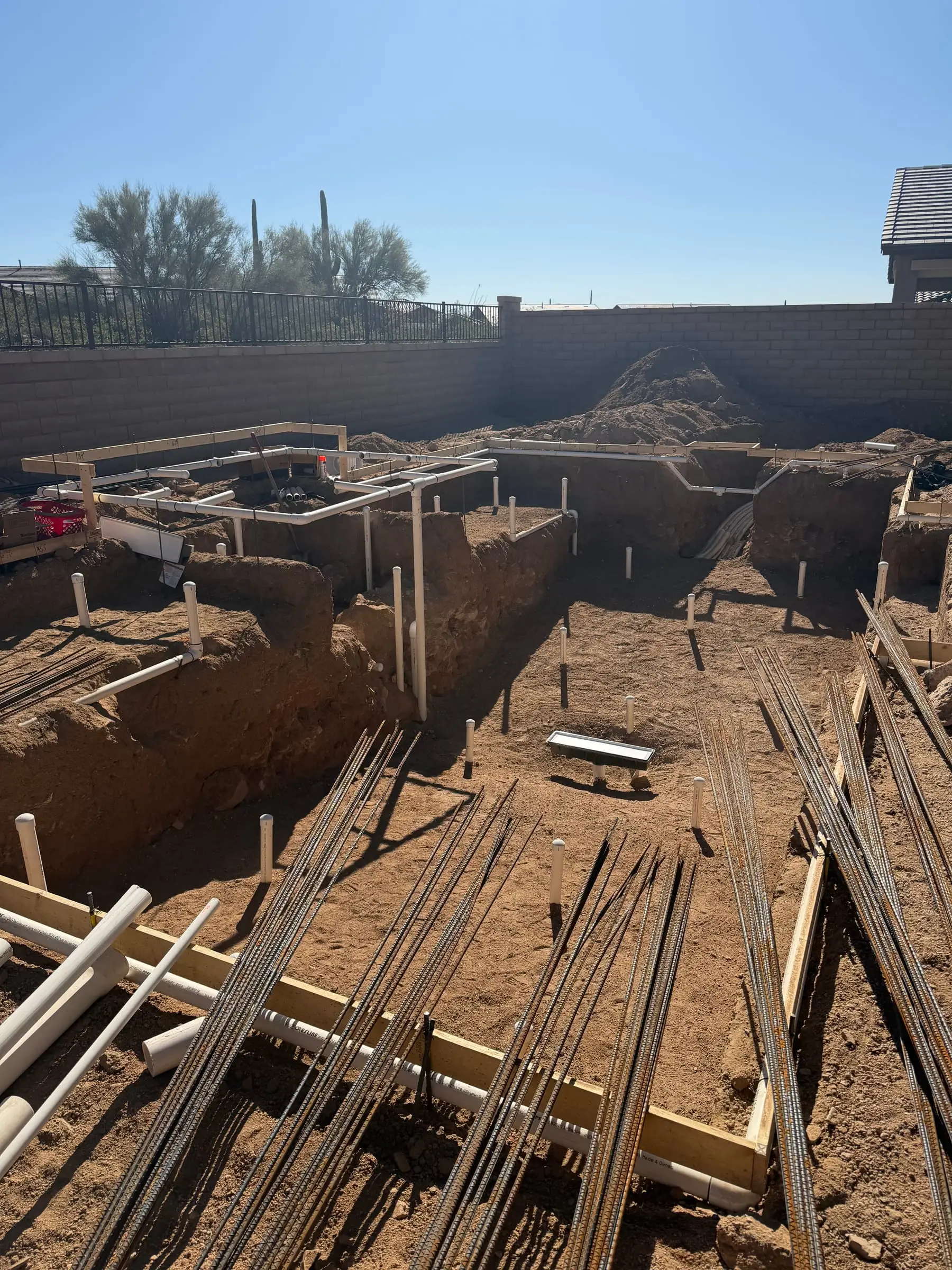 Rebar bundles and wood forms set in a pool and spa excavation.