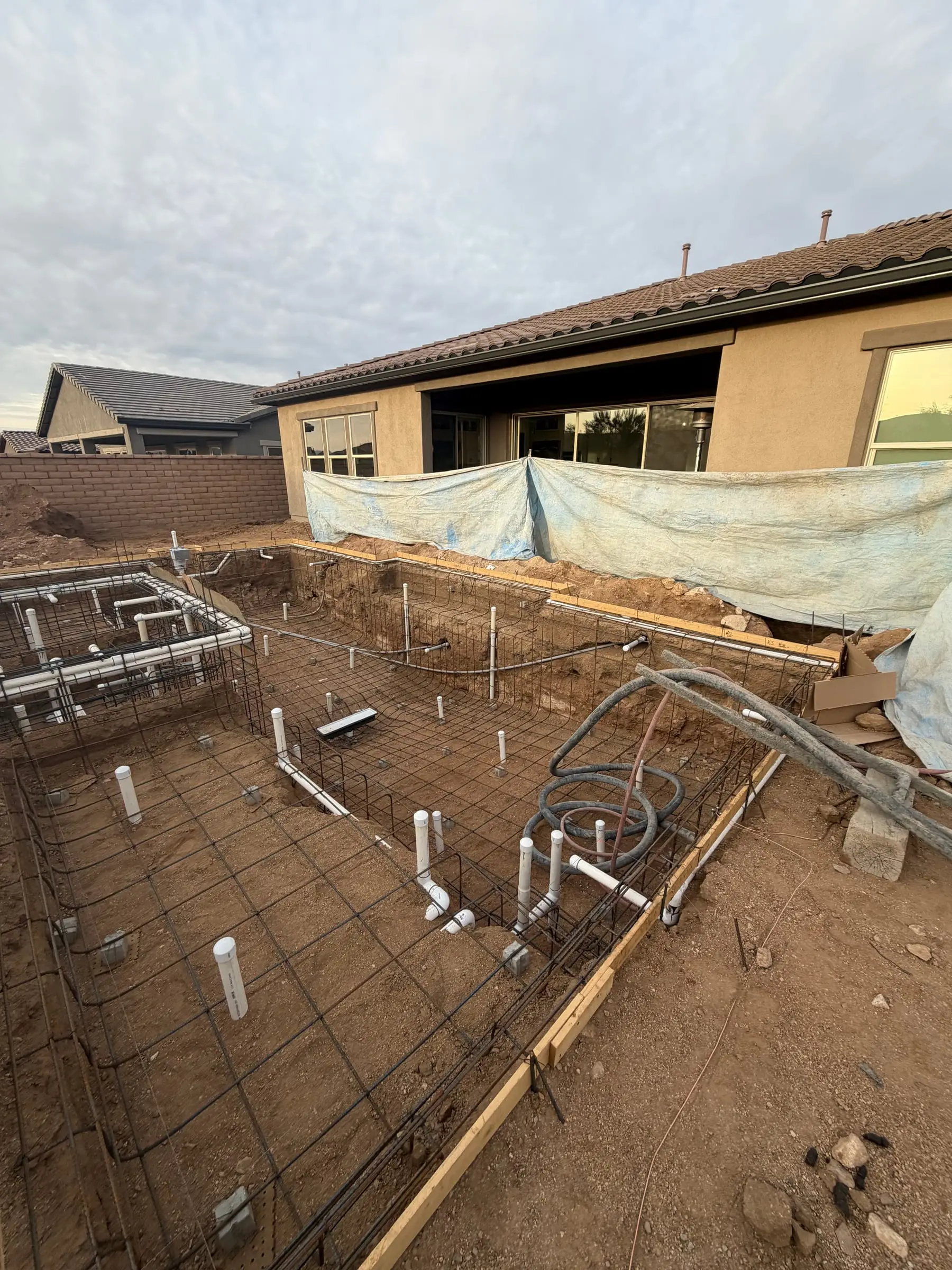 Rebar grid and plumbing stubs for a pool and raised spa inside wood forms, Marana, AZ.