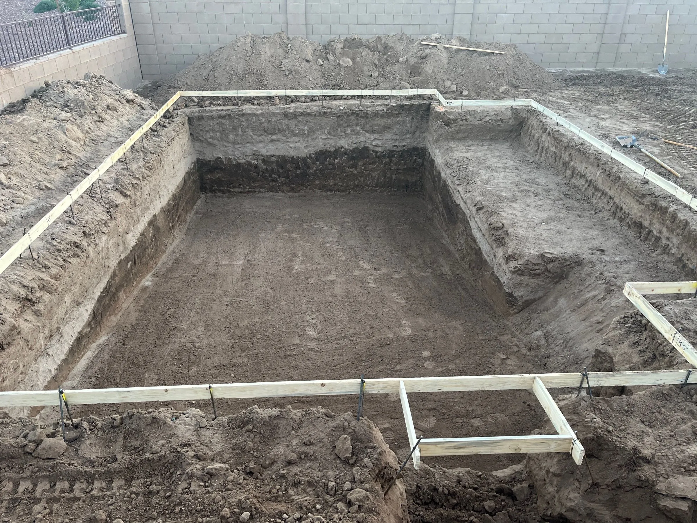 Rectangular pool excavation framed with wood forms, including a stepped shallow end, in Marana.