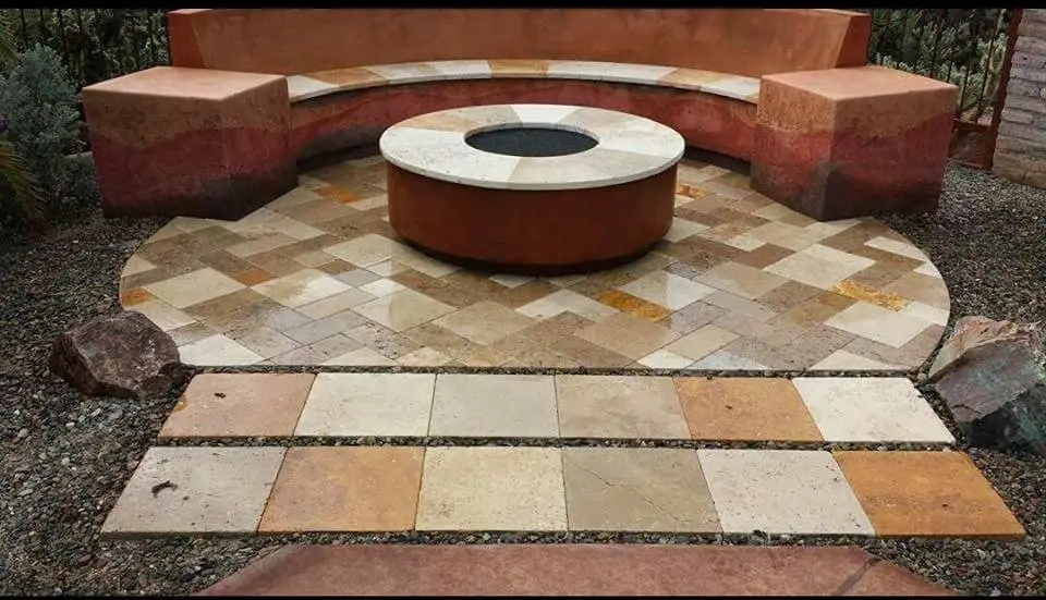 Round fire pit with travertine cap and curved bench on a travertine patio with stepping pads.