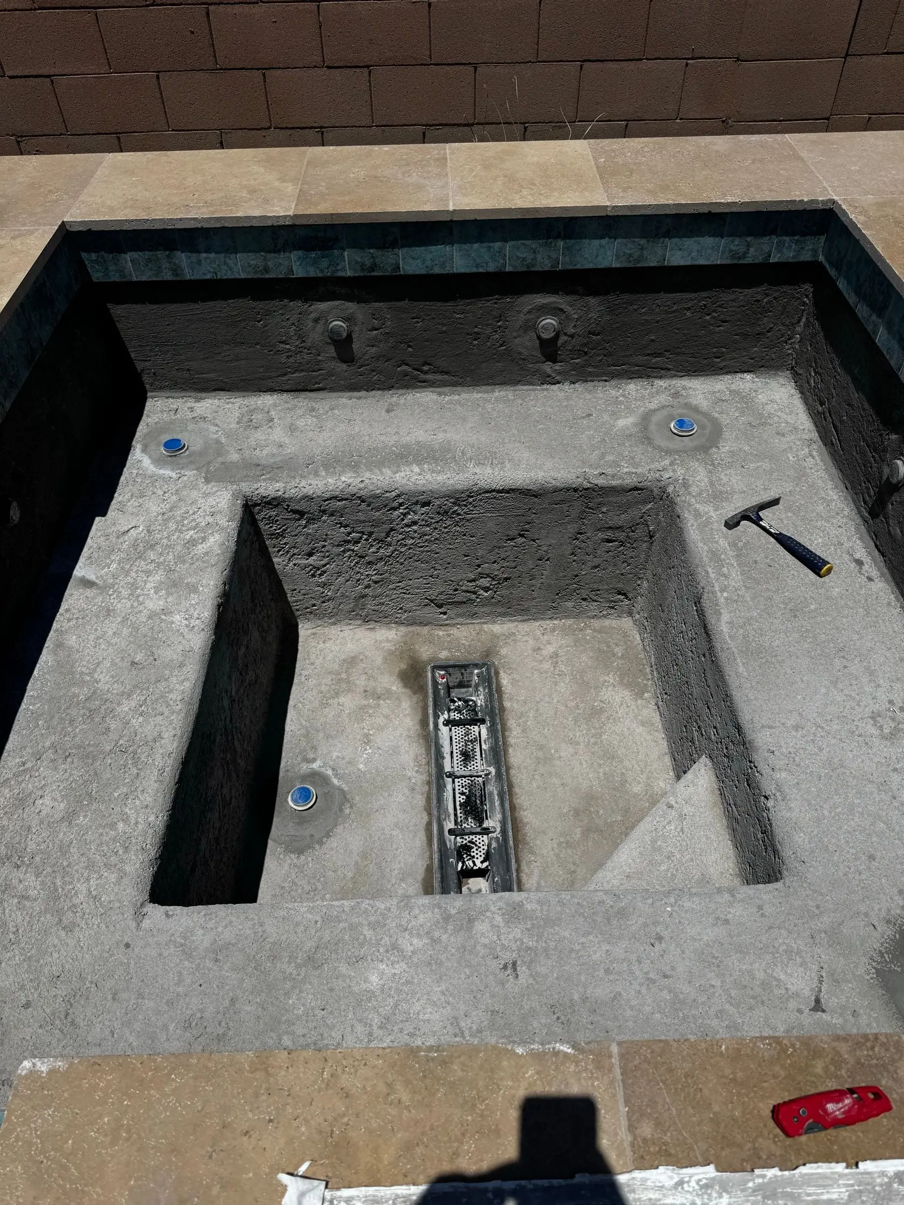 Close view of a spa shell with seating bench, jet fittings and center drain before plaster, Marana, AZ.