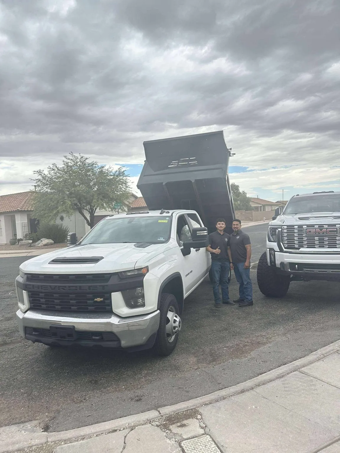Meraki Pools AZ owners standing beside their dump truck and work truck